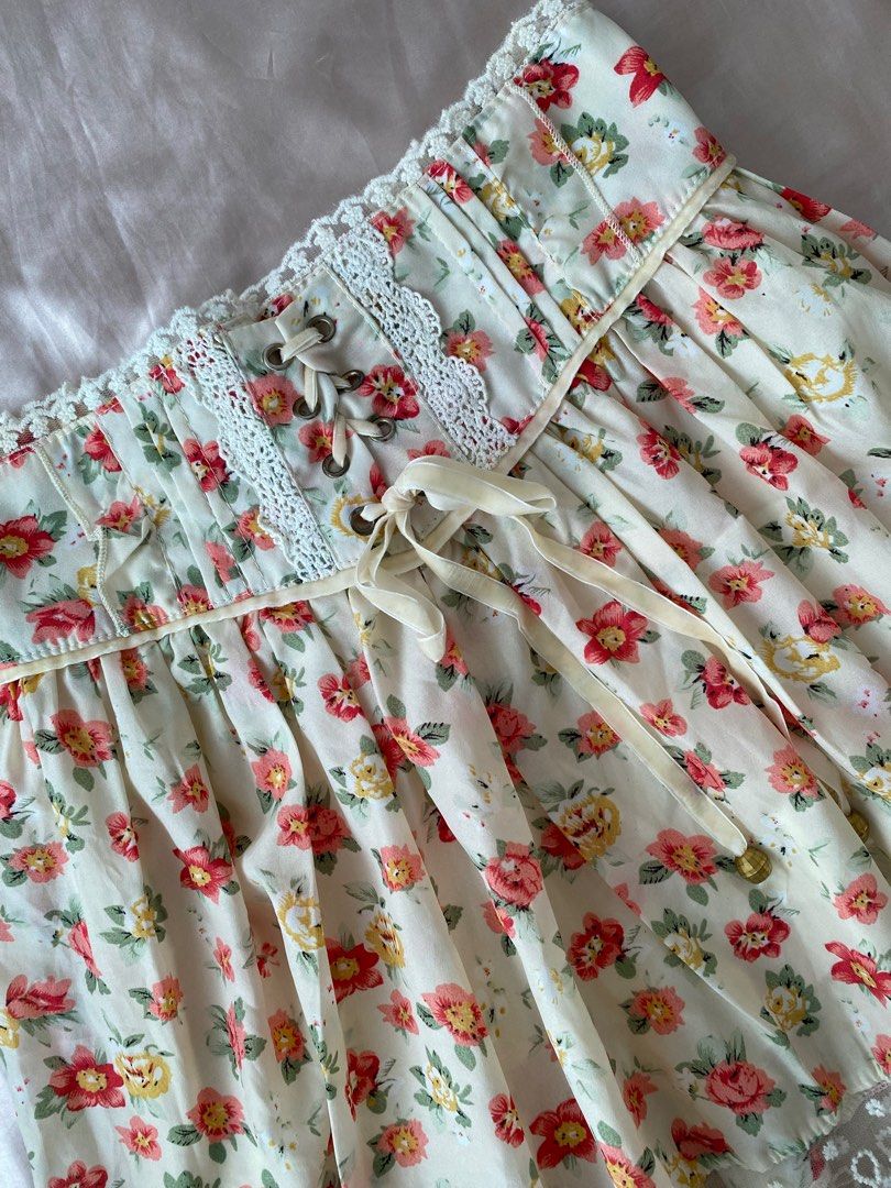 Floral Lace Trim Skirt (Category: Skirts) located in Manila. Submitted by herwears (Listing ID 1404746196, Image 3). Description: - Cream-colored skirt with red and yellow floral print. - Features delicate lace trim. - Corset-style waist with ribbon tie. - Lightweight fabric, ideal for warm weather..
