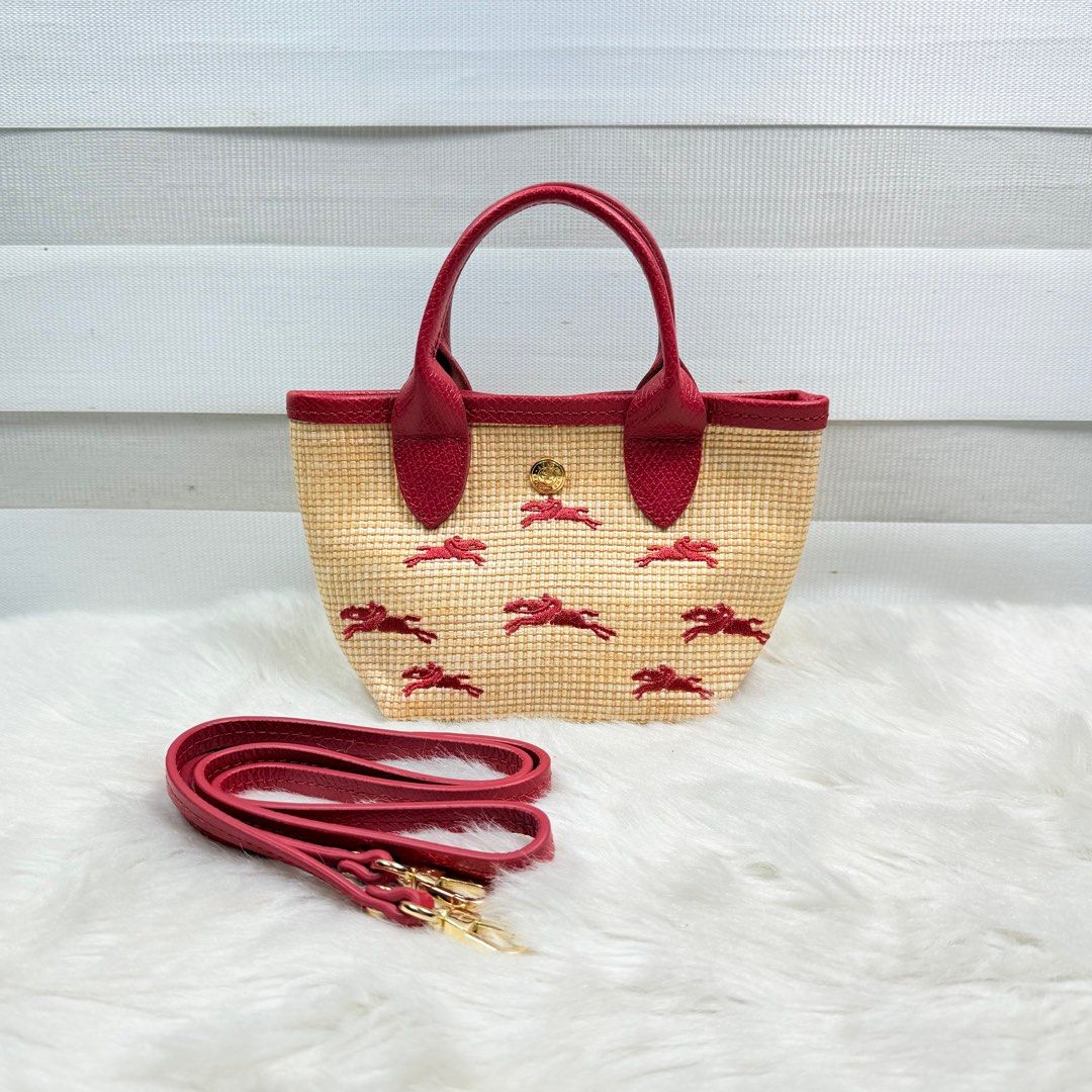 Micro Longchamp Paris Straw Tote Bag (Category: Luxury Bags & Wallets) located in Pasig City. Submitted by trendapparelph (Listing ID 1404738009, Image 1). Description: - micro Longchamp Paris Straw Tote Bag - Woven straw material - Red leather trim and handles - Embroidered with the iconic Longchamp horse logo - Includes a detachable strap.