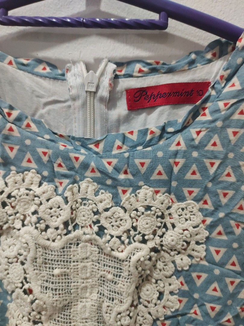Peppermint Blue Geometric Dress with Lace (Category: Babies & Kids Fashion) located in Valenzuela. Submitted by annday (Listing ID 1404673216, Image 2). Description: - Blue geometric pattern with red triangle accents - Delicate white lace detail on bodice - Zipper closure at the back - Short sleeves - Fitted waist - Brand tag visible - Unique and stylish design.