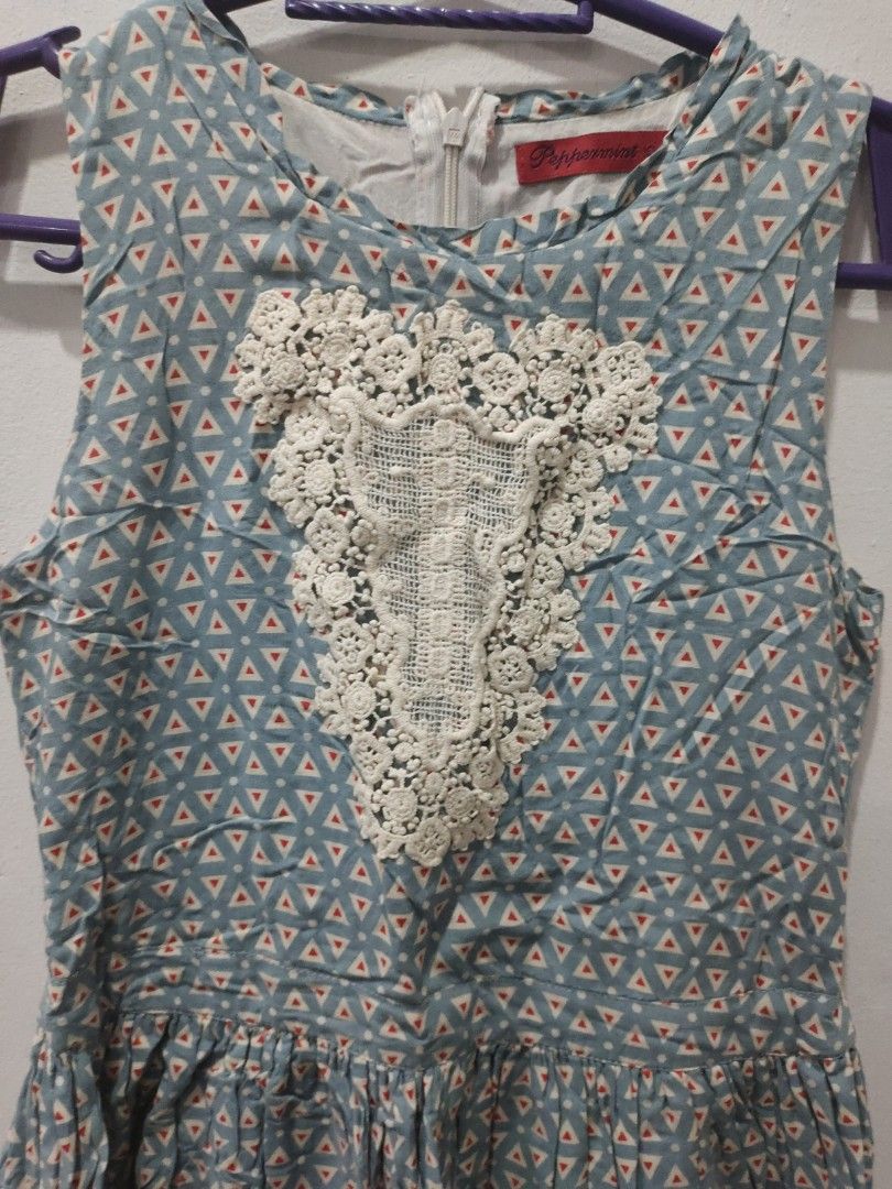 Peppermint Blue Geometric Dress with Lace (Category: Babies & Kids Fashion) located in Valenzuela. Submitted by annday (Listing ID 1404673216, Image 3). Description: - Blue geometric pattern with red triangle accents - Delicate white lace detail on bodice - Zipper closure at the back - Short sleeves - Fitted waist - Brand tag visible - Unique and stylish design.
