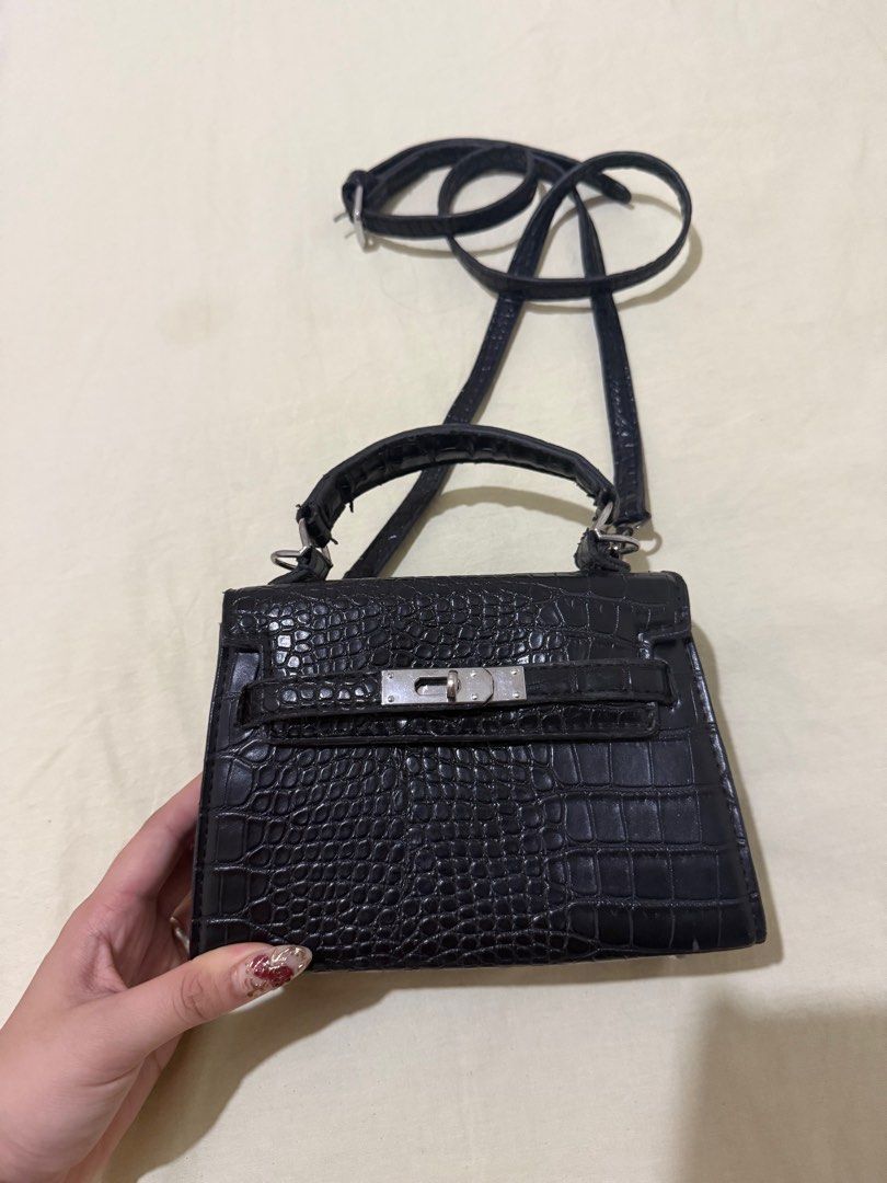 Hermes Kelly Mini Handbag (Category: Luxury Bags & Wallets) located in Angono. Submitted by xxxallaboutbagsxxx (Listing ID 1404934958, Image 3). Description: Black mini handbag with crocodile-embossed design. Features a top handle, detachable shoulder strap, and silver-tone hardware. Includes a small zippered pocket. Made of faux leather. Price negotiable.