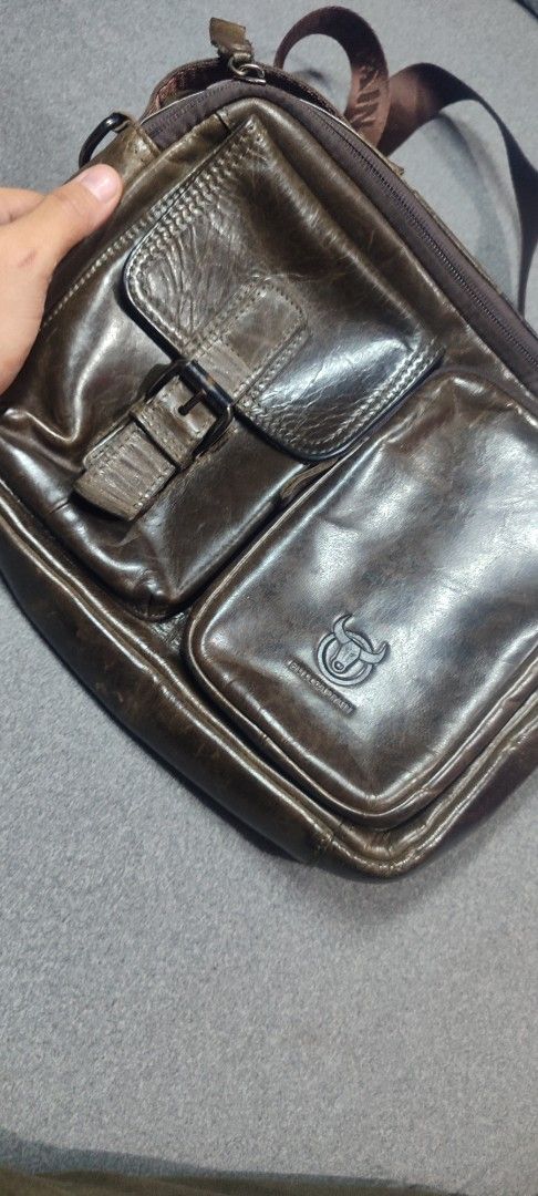 Bullcaptain Leather Messenger Bag (Category: Sling Bags) located in Rizal. Submitted by chicout (Listing ID 1404907212, Image 3). Description: - Bullcaptain brown leather messenger bag - Multiple compartments for storage - Two front pockets with buckle closure - Adjustable brown shoulder strap with brand name - Brand logo on the front - Branded tag inside - Ideal for daily use.