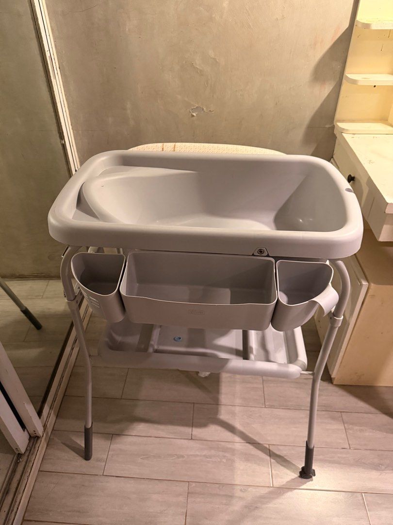 Chicco Baby Changing Table (Category: Other Baby Bathing & Changing Needs) located in Cavite. Submitted by kleaningoutmykloset (Listing ID 1404835703, Image 2). Description: NEGOTIABLE. Chicco baby changing table features a changing pad and a built-in baby bath. It has a sturdy frame with storage compartments for essentials. The table is designed with a neutral color scheme, making it suitable for any nursery..