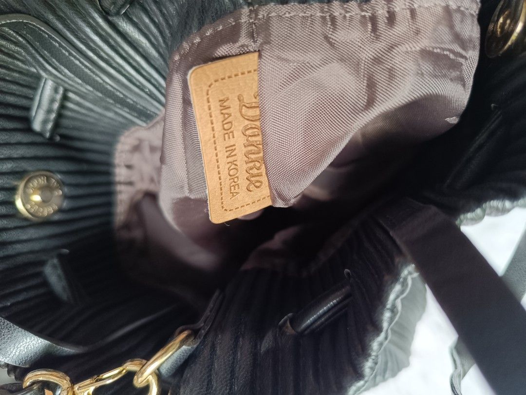 Donnie Pleated Bucket Bag (Category: Luxury Bags & Wallets) located in Digos. Submitted by venusacaro13427 (Listing ID 1404868255, Image 3). Description: - Donnie black pleated bucket bag - Drawstring closure - Shoulder strap - Structured design with vertical pleats - Lined interior - Brand tag - Handle for carrying - Gold-colored hardware.