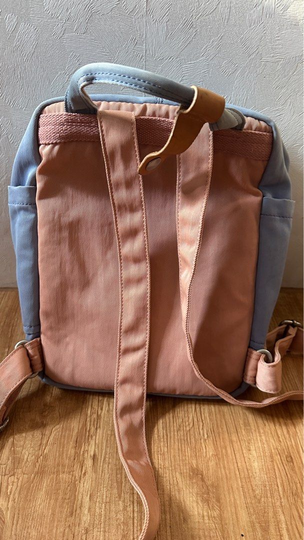 Doughnut Backpack （分類：背囊）位於 Hong Kong。 由 aau209 提交（商品編號 1404774708，圖片 2）。簡介： Authentic Doughnut backpack features a combination of blue and pink colours. It has a front flap with buckle closures and a top handle. The backpack has side pockets and adjustable shoulder straps. The brand's logo is visible on the front. 新舊見圖，尖沙咀／金鐘／炮台山地鐵站交收。