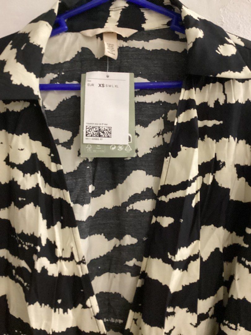 H&M Collared Wrap Dress - Black/Tiger-Striped (Category: Dresses) located in Taytay. Submitted by storedbys (Listing ID 1404872975, Image 2). Description: H&M collared wrap dress in black and tiger-striped pattern. Features long-sleeves with flared cuffs and a tie waist. The dress has V-neckline and a midi-length. Size XS is indicated on the tag. The dress is new with tags..