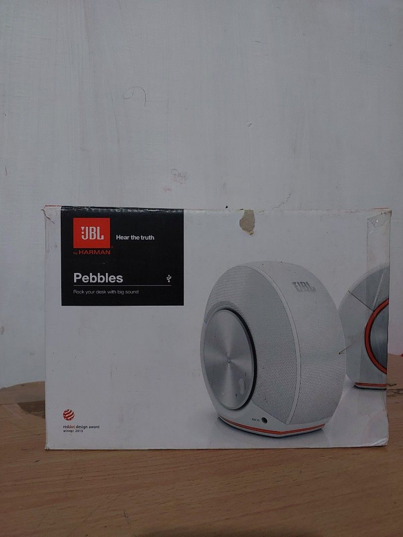JBL Pebbles Speakers (Category: Soundbars, Speakers & Amplifiers) located in Quezon City. Submitted by jpnvintageonline (Listing ID 1404793816, Image 1). Description: - JBL Pebbles speakers - Color: White and Silver - Includes original box - Unique design: - Mesh speaker cover - Orange accents - Metallic center - Circular shape - JBL logo visible - Features Red Dot Design Award logo.