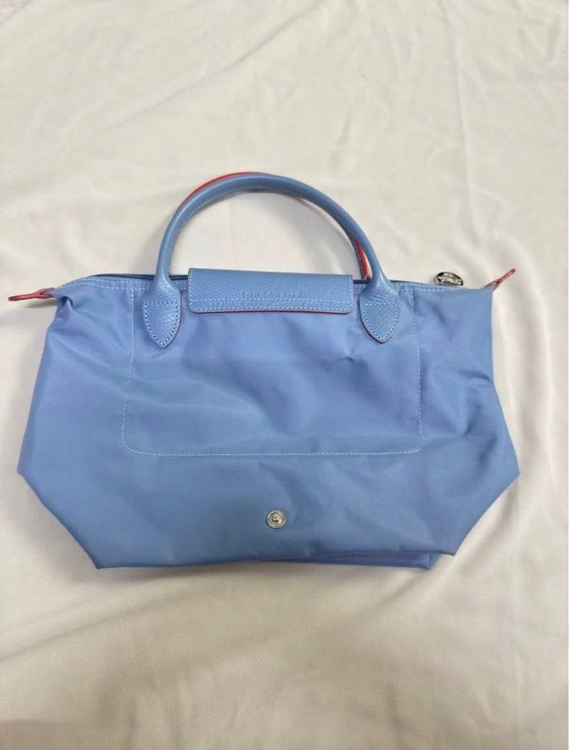 LONGCHAM (Category: Clutches) located in Kuala Lumpur. Submitted by fazlyanafth (Listing ID 1404905105, Image 3). Description: - Authentic Longchamp Le Pliage handbag - Light blue nylon body - Matching leather handles and flap - Red trim on handles - Embroidered horse logo - RRP: RM 700+ - Include Zalora Lux dustbag - ⁠Sell : RM 290.