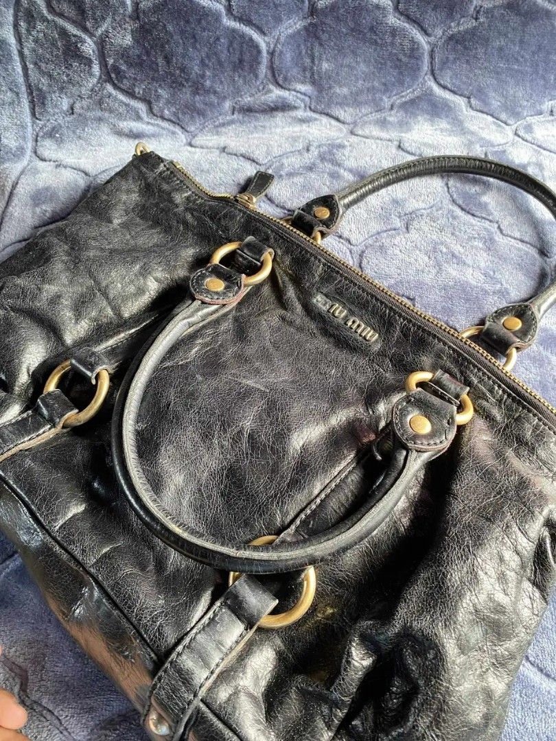 Miu Miu Black Leather Handbag (Category: Luxury Bags & Wallets) located in Taguig. Submitted by jerafelsan87737 (Listing ID 1404955230, Image 1). Description: - Authentic Miu Miu handbag - Black leather with gold-tone hardware - Double top handles - Secure zip closure - Spacious interior - Visible Miu Miu logo - Minor signs of wear.