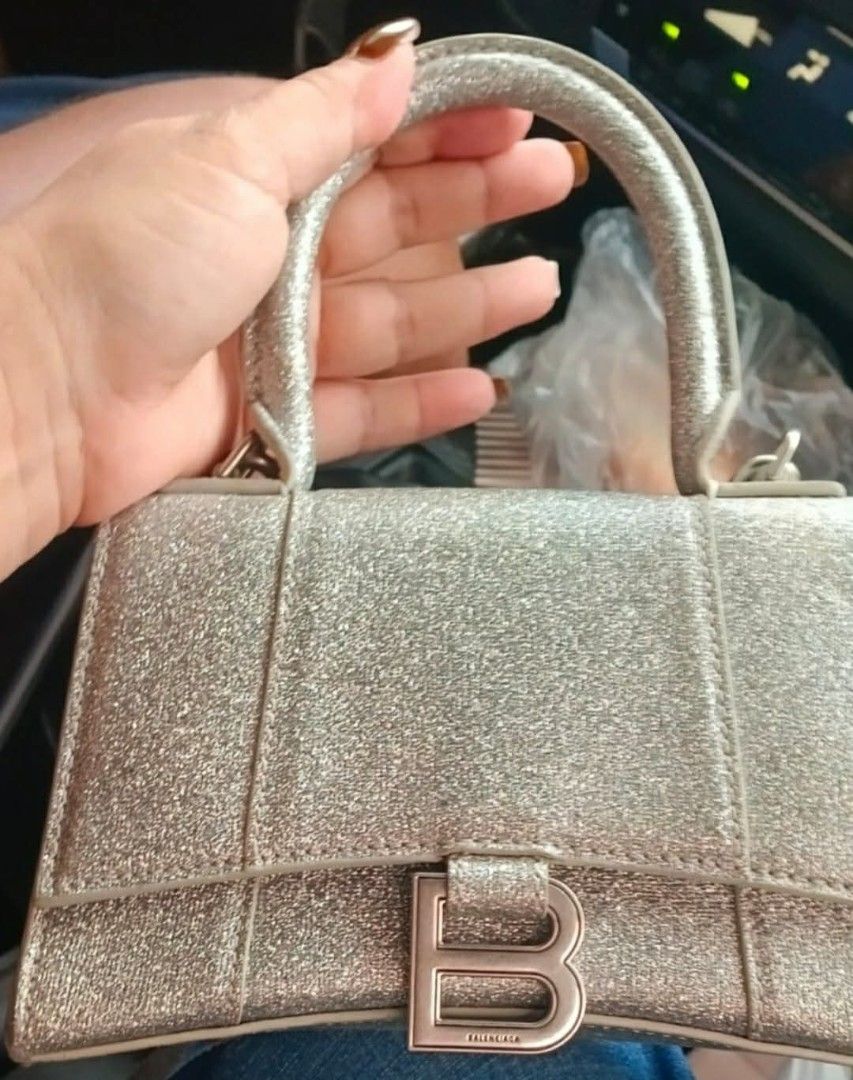Balenciaga Hourglass Glitter Bag (Category: Luxury Bags & Wallets) located in Legazpi City. Submitted by georgepine07142 (Listing ID 1405149926, Image 2). Description: The Balenciaga Glitter Hourglass Small Top Handle Bag is a stunning piece to elevate your Balenciaga collection. Made from glitter fabric with its signature structured hourglass silhouette, it features sleek curves, matte hardware, and a lambskin-lined interior that truly set it ap