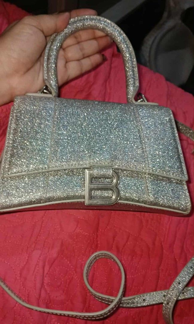 Balenciaga Hourglass Glitter Bag (Category: Luxury Bags & Wallets) located in Legazpi City. Submitted by georgepine07142 (Listing ID 1405149926, Image 1). Description: The Balenciaga Glitter Hourglass Small Top Handle Bag is a stunning piece to elevate your Balenciaga collection. Made from glitter fabric with its signature structured hourglass silhouette, it features sleek curves, matte hardware, and a lambskin-lined interior that truly set it ap