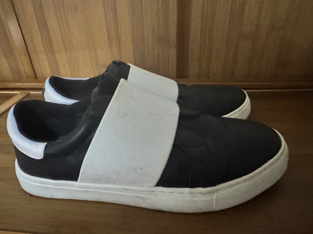Black and White Slip-on Sneakers (Category: Sneakers) located in Quezon City. Submitted by 3kings2018 (Listing ID 1405107467, Image 2). Description: - Stylish black slip-on sneakers - White elastic band detail - White sole and heel accent - Features a small logo - Sleek and modern design - Ideal for everyday wear.