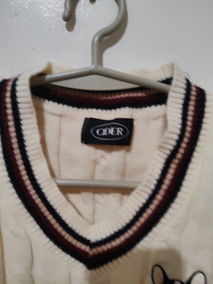 CIDER Dog Patch Sweater Vest (Category: Sleeveless) located in Valenzuela. Submitted by aliehs.alo (Listing ID 1405065981, Image 3). Description: - Cream-colored cable knit sweater vest - V-neck design - Burgundy and black striped accents - Adorable embroidered dog patch - Perfect for layering - Brand tag visible.