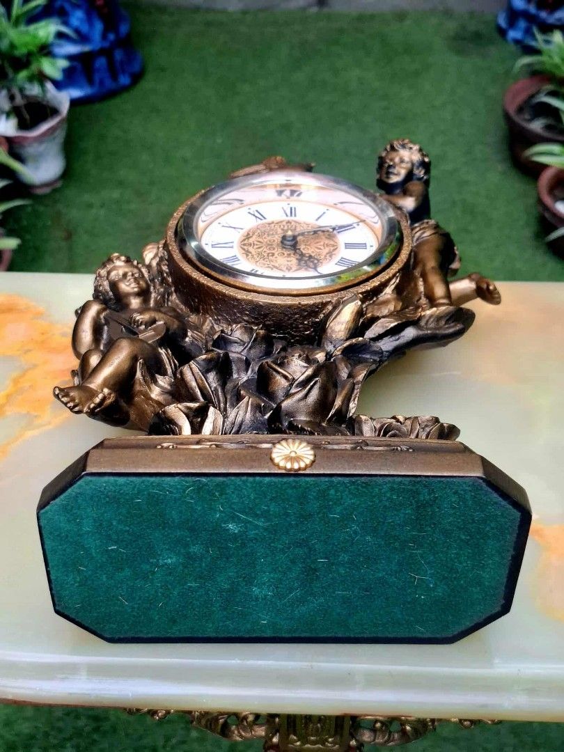 Citizen Quartz Table Clock with Cherubs (Category: Clocks) located in Malabon City. Submitted by justineevglst (Listing ID 1405006070, Image 3). Description: - Citizen quartz table clock - Roman numeral display - Decorative face with cherub figurines and rose accents - Gold-toned finish - Green felt base - Includes a small drawer - Perfect decorative item.