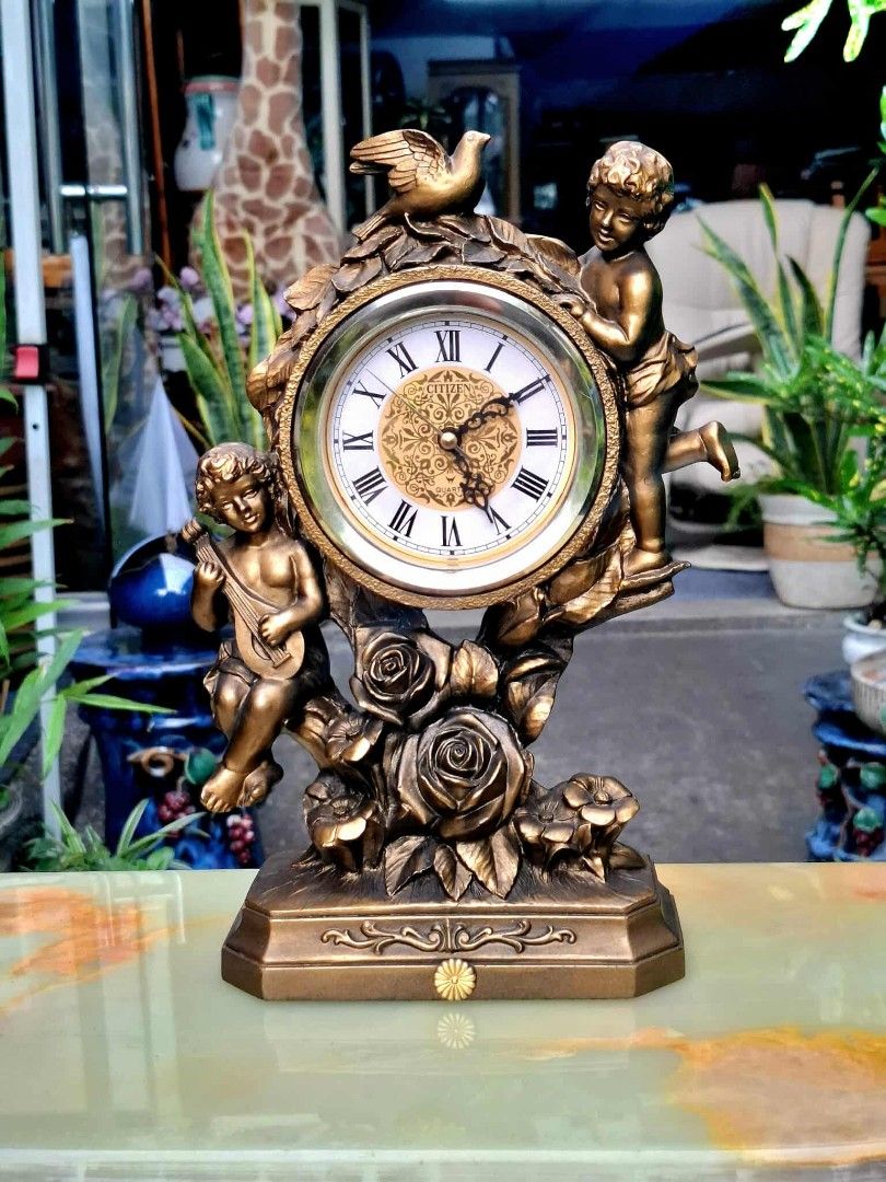 Citizen Quartz Table Clock with Cherubs (Category: Clocks) located in Malabon City. Submitted by justineevglst (Listing ID 1405006070, Image 1). Description: - Citizen quartz table clock - Roman numeral display - Decorative face with cherub figurines and rose accents - Gold-toned finish - Green felt base - Includes a small drawer - Perfect decorative item.
