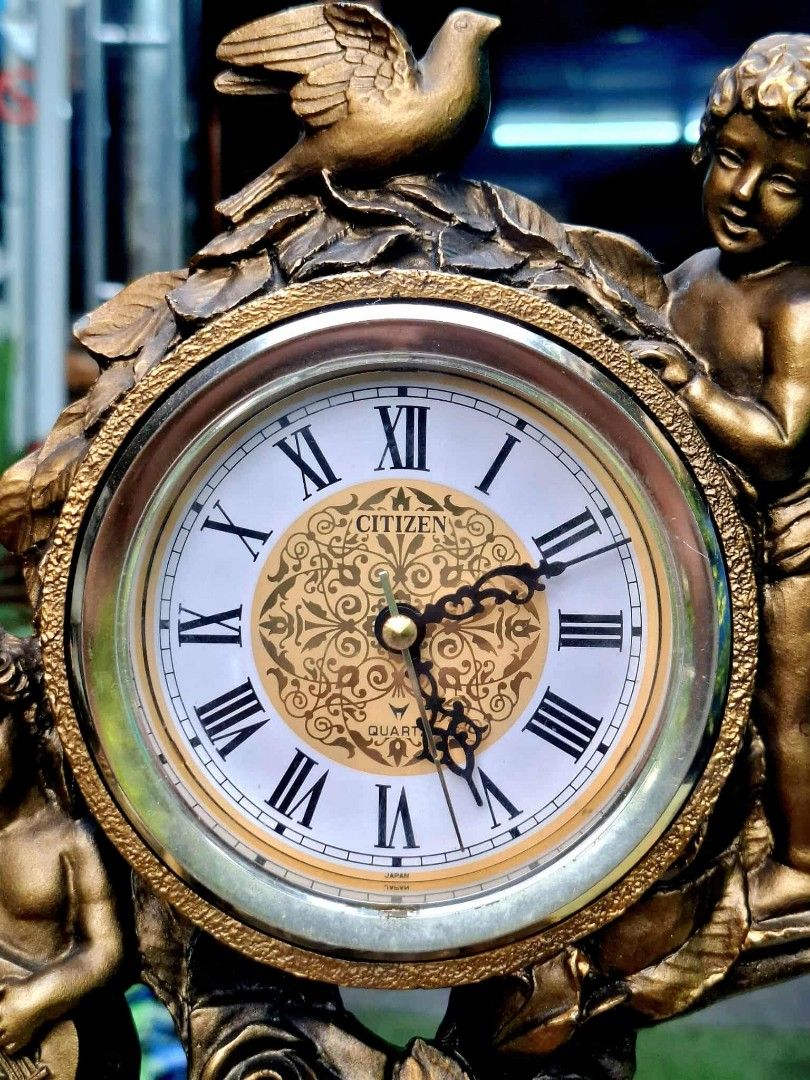 Citizen Quartz Table Clock with Cherubs (Category: Clocks) located in Malabon City. Submitted by justineevglst (Listing ID 1405006070, Image 2). Description: - Citizen quartz table clock - Roman numeral display - Decorative face with cherub figurines and rose accents - Gold-toned finish - Green felt base - Includes a small drawer - Perfect decorative item.