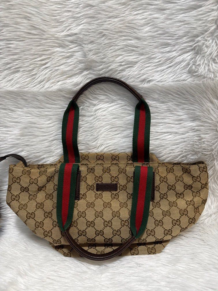 G ucci canvas Sherry Line mini (Category: Luxury Bags & Wallets) located in Mandaluyong City. Submitted by tigresscloset (Listing ID 1405014516, Image 2). Description: 100% authentic Gucci GG canvas tote bag with the signature Web stripe handles in beige, red, and green Material: The main body is made from the iconic GG canvas with leather trim and handles. Design: It features the signature red and green “Web” or “Sherry” stripes on the flat top 