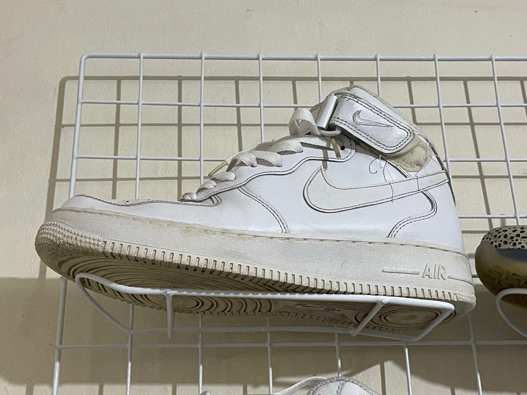 Nike Air Force 1 Mid White (Category: Sneakers) located in Lupao. Submitted by jennylynda42204 (Listing ID 1404968802, Image 2). Description: - White Nike Air Force 1 Mid sneakers - Iconic Nike swoosh - Mid-top design with strap - Visible wear on soles and uppers - White laces.