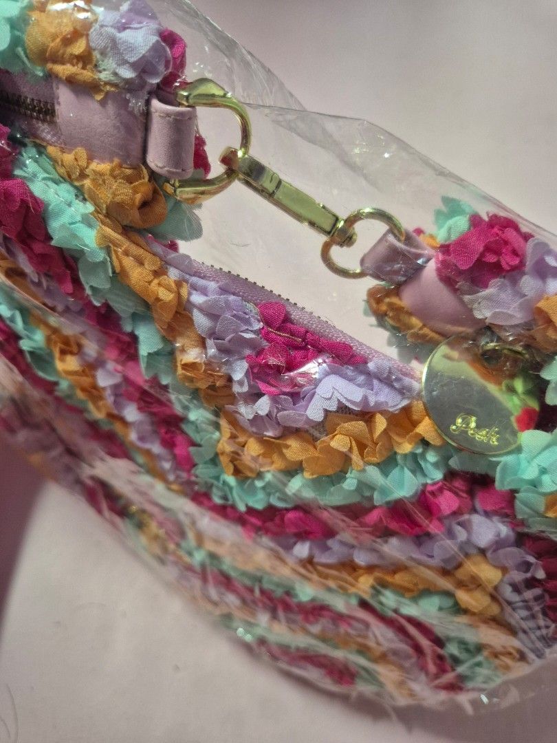 Posh Ruffled Handbag with Chain Strap from Thailand (Category: Luxury Bags & Wallets) located in Manila. Submitted by bangtanroxyy (Listing ID 1405039583, Image 3). Description: - Brand new colorful handbag - Unique ruffled design in pink, orange, purple, and blue - Includes a detachable pink and gold chain strap - Secure zipper closure - Gold-toned Posh logo - Comes in original packaging - From Thailand - Posh is a Thailand brand.