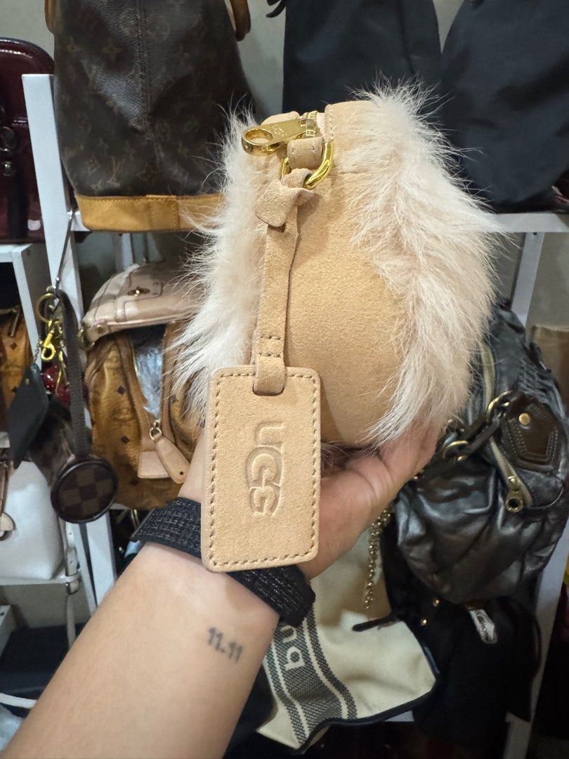 UGG Fur Clutch Bag (Category: Luxury Bags & Wallets) located in Cagayan de Oro. Submitted by KoaApparelAtbp. (Listing ID 1405155249, Image 2). Description: - Authentic UGG clutch bag - Soft fur exterior - Elegant beige color - Secure zip closure - Detachable strap for versatile carrying - Interior pocket for essentials - Gold-tone zipper adds a touch of luxury - UGG tag visible for authenticity - Comes with original cards.