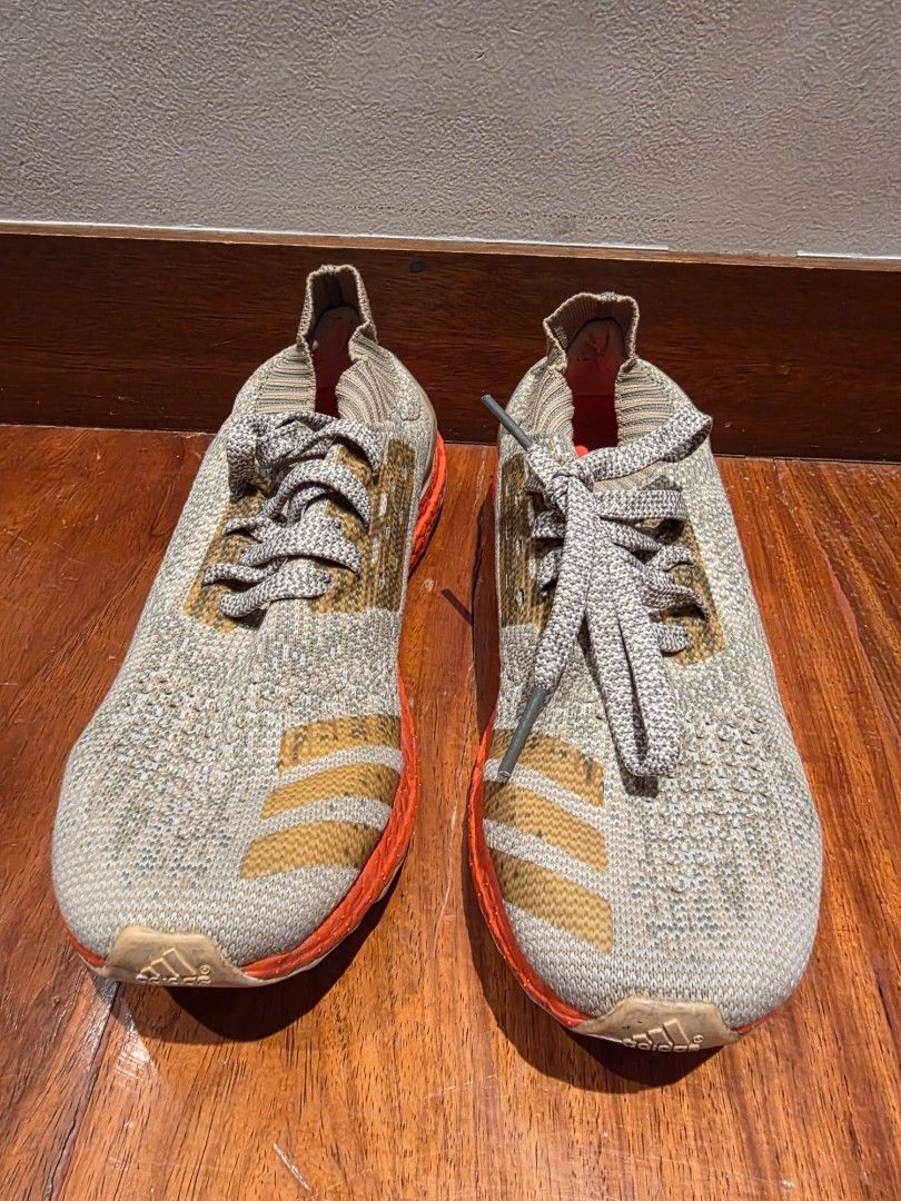 Adidas Ultraboost Sneakers (Category: Sneakers) located in Pasig City. Submitted by vthing (Listing ID 1401867262, Image 1). Description: Adidas Ultraboost sneakers with a grey and orange color scheme. Features the Adidas logo on the side. The shoes have grey laces and a knitted upper. The soles are orange and the bottom of the shoes have a Continental sole..