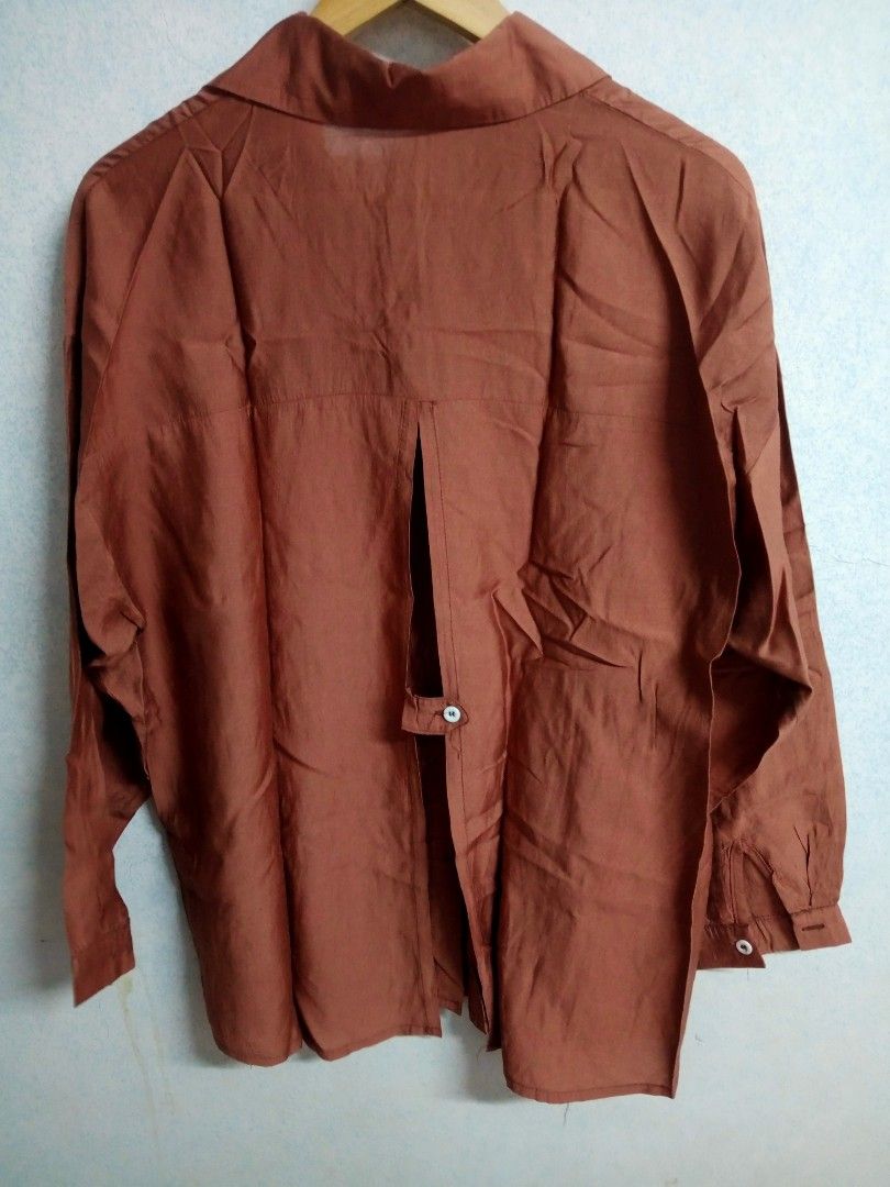 Brown Long Sleeve Blouse (Category: Blouses) located in Bulacan. Submitted by ely46 (Listing ID 1401846306, Image 2). Description: - Brown long-sleeved blouse - Collared neckline - Button-down front - Unique split back design with single button closure - Long sleeves with buttoned cuffs - Lightweight fabric - Suitable for warm weather - Brand new.