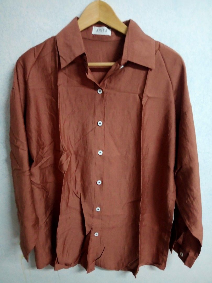 Brown Long Sleeve Blouse (Category: Blouses) located in Bulacan. Submitted by ely46 (Listing ID 1401846306, Image 1). Description: - Brown long-sleeved blouse - Collared neckline - Button-down front - Unique split back design with single button closure - Long sleeves with buttoned cuffs - Lightweight fabric - Suitable for warm weather - Brand new.