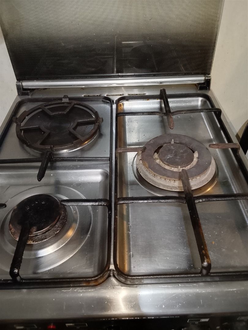 Gas Range with Oven (Category: Ovens & Toasters) located in Quezon City. Submitted by albertoferryanne50 (Listing ID 1401910353, Image 3). Description: gas range with four burners and an oven. Features control knobs for burner and oven temperature adjustments. Includes oven racks. The exterior is a combination of silver and black. has electric coil for back up if maubos ang gasul.. will transfer to a smaller place kaya selling.