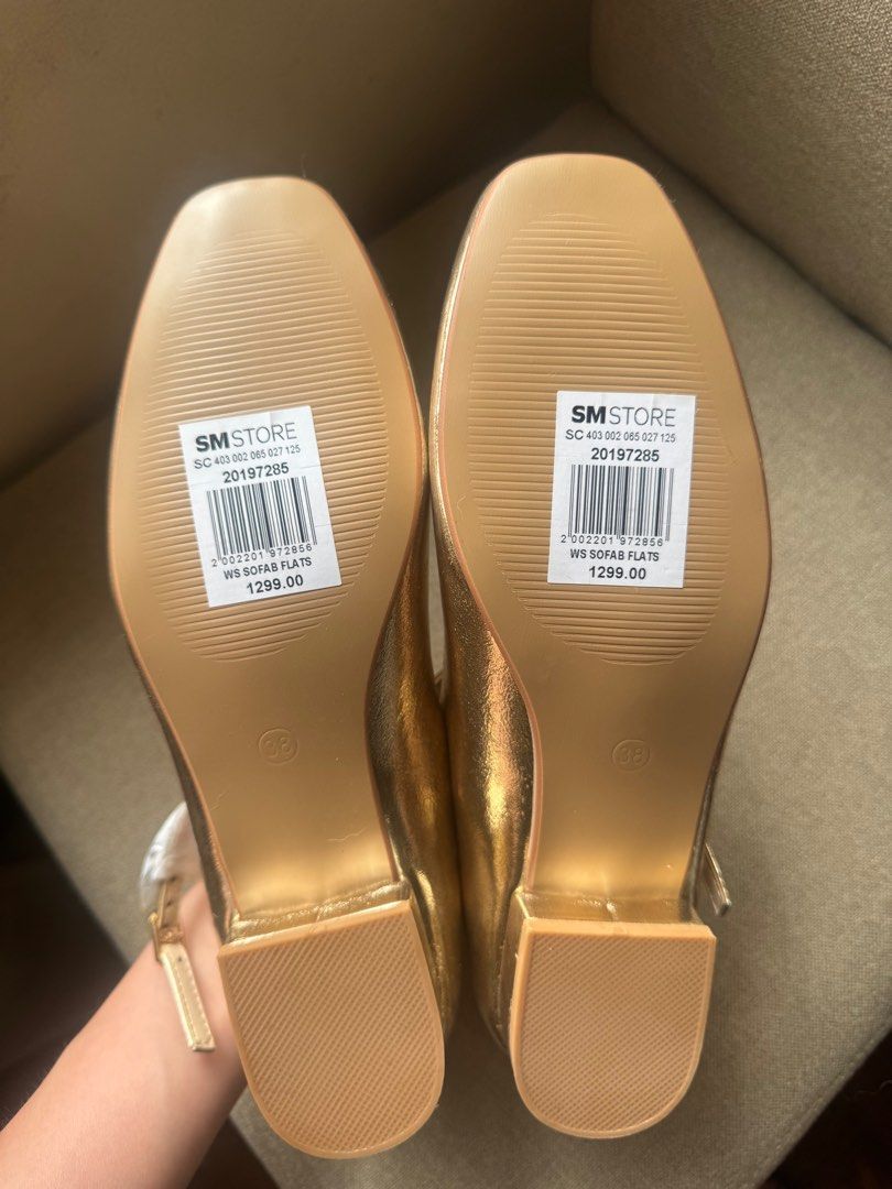 Gold Sofab Flats Mary Janes (Category: Flats & Sandals) located in Manila. Submitted by modernitaph (Listing ID 1401764402, Image 3). Description: - Gold-colored flats from SM Store - Size 38 - Square toe design - Strap across the top of the foot - Unworn condition - Original price: ₱1299.00 -issues: patches due to storage (see photo).