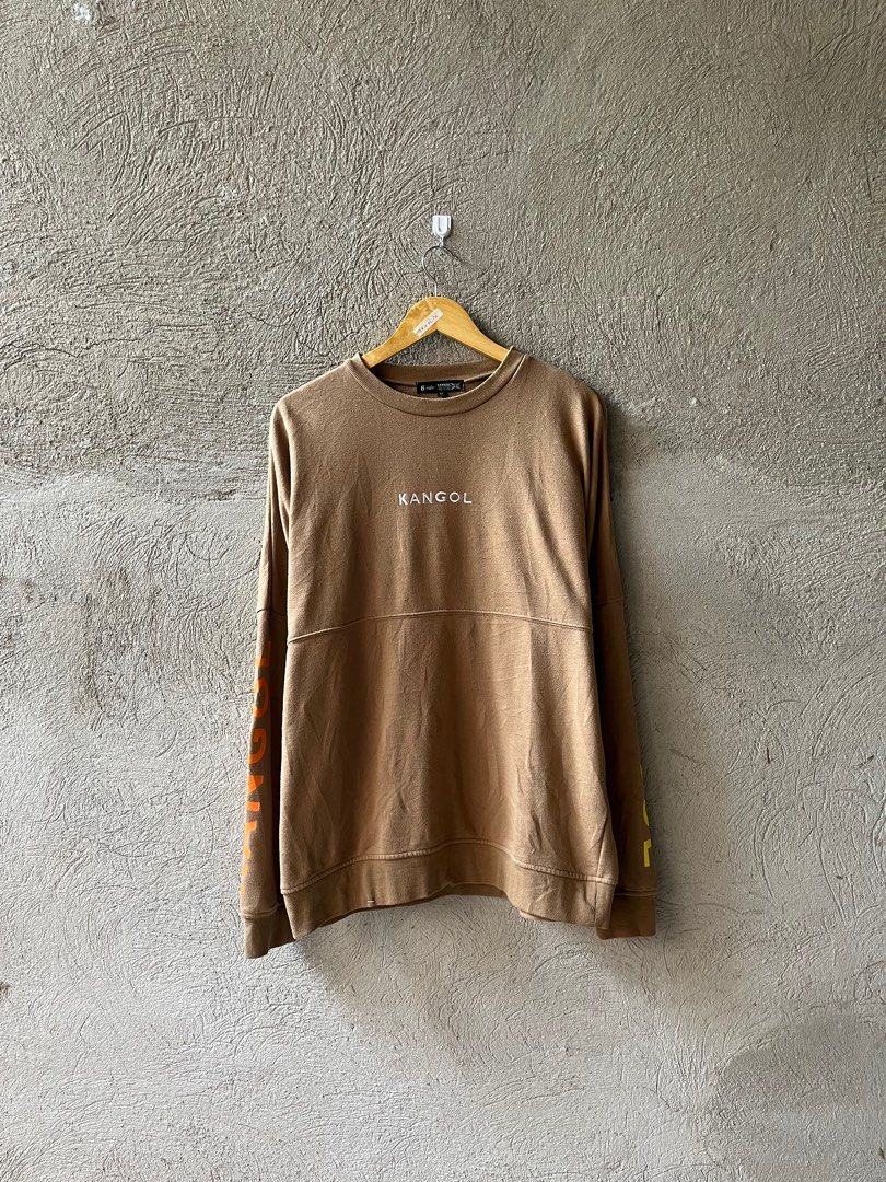 Kangol Sweatshirt - Brown - Size M (Category: Coats, Jackets and Outerwear) located in Famy. Submitted by basicthrifted (Listing ID 1401845515, Image 1). Description: - Kangol Sweatshirt - Brown color - Size M - Features Kangol logo - Unique sleeve design.