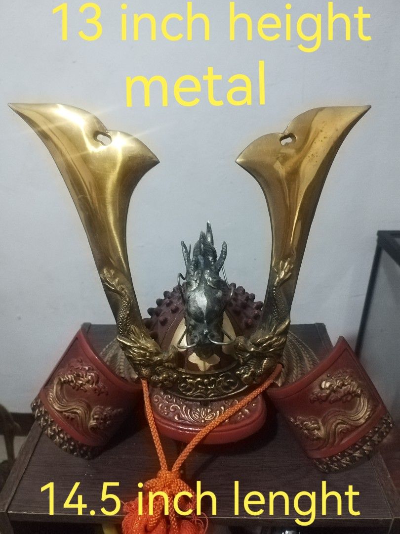 Metal Samurai Helmet - 13 inch Height (Category: Vintage Collectibles) located in San Rafael. Submitted by jflshoppe1989 (Listing ID 1401718359, Image 1). Description: Metal samurai helmet features a unique design with a 13-inch height and 14.5-inch length. It has intricate details, including dragon motifs and a decorative orange tassel. The helmet's color scheme includes gold and red accents..