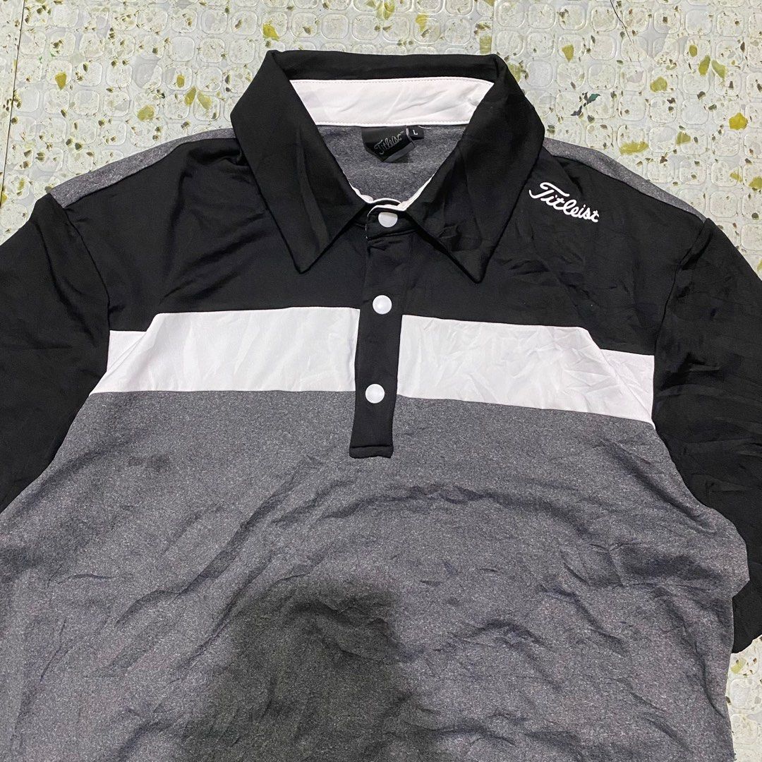 Titleist Golf Polo Shirt - Large (Category: Tshirts & Polo Shirts ) located in Cebu City. Submitted by vast_trese.13 (Listing ID 1401905142, Image 2). Description: - Titleist golf polo shirt - Size: Large - Color block design: black collar and sleeves, white chest stripe, gray body - Titleist logo on collar - Classic polo collar and button closure.