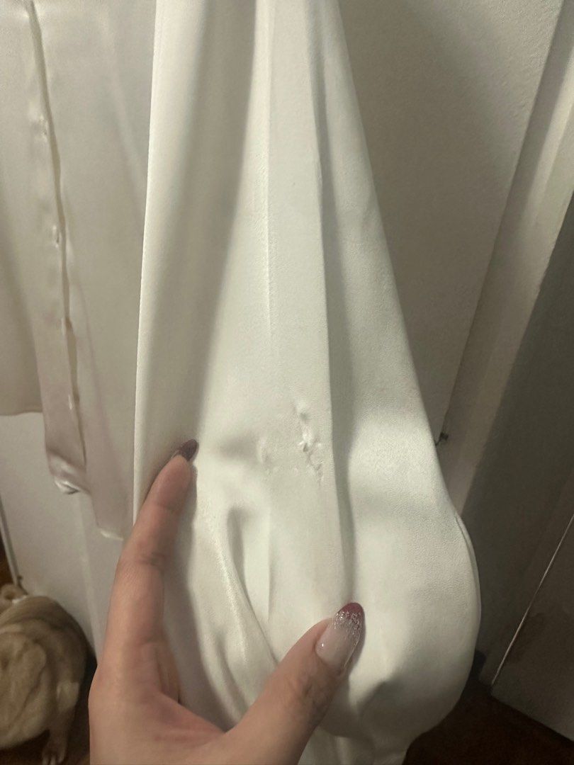 Uniqlo White Satin Blouse - Size M (Category: Blouses) located in Quezon City. Submitted by izha30 (Listing ID 1401894823, Image 3). Description: White satin blouse from Uniqlo, size M. Features long sleeves and button-down closure. Made in China. There are some small holes on the left sleeve. The blouse has a classic, elegant design, suitable for various occasions..