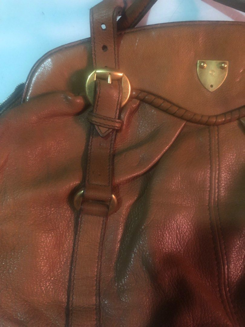 Alexander McQueen Leather Handbag (Category: Luxury Bags & Wallets) located in Bacoor. Submitted by well_curated (Listing ID 1405253667, Image 2). Description: - Authentic Alexander McQueen handbag - Genuine leather - Dual-tone brown design - Gold-tone hardware - Includes top handle and shoulder strap - Interior zipper closure - Made in Italy - Unique shield-shaped emblem.