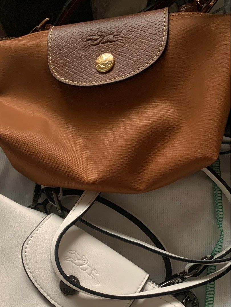 Authentic Longchamp Le Pliage Crossbody Bag (Category: Luxury Bags & Wallets) located in Manila. Submitted by leigh_dior (Listing ID 1405280393, Image 1). Description: - Two Longchamp Le Pliage Crossbody Bags - Colors: Tan with Brown Flap, White - Features: Flap Closure with Longchamp Logo, Chain Strap - Includes: Longchamp Dust Bag.