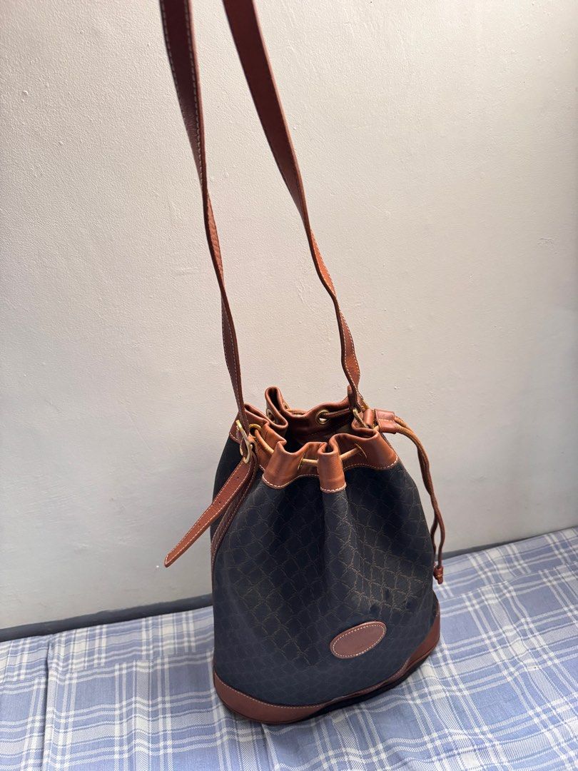 Longchamp Vintage Leather Bucket Bag (Category: Luxury Bags & Wallets) located in Rosales. Submitted by thriftingismygame (Listing ID 1405217703, Image 3). Description: - Vintage Longchamp bucket bag - Brown leather trim and strap - Drawstring closure - Brown patterned exterior - Features Longchamp logo patch - Beige interior with zipper pocket - Made in France Some few signs of usage.