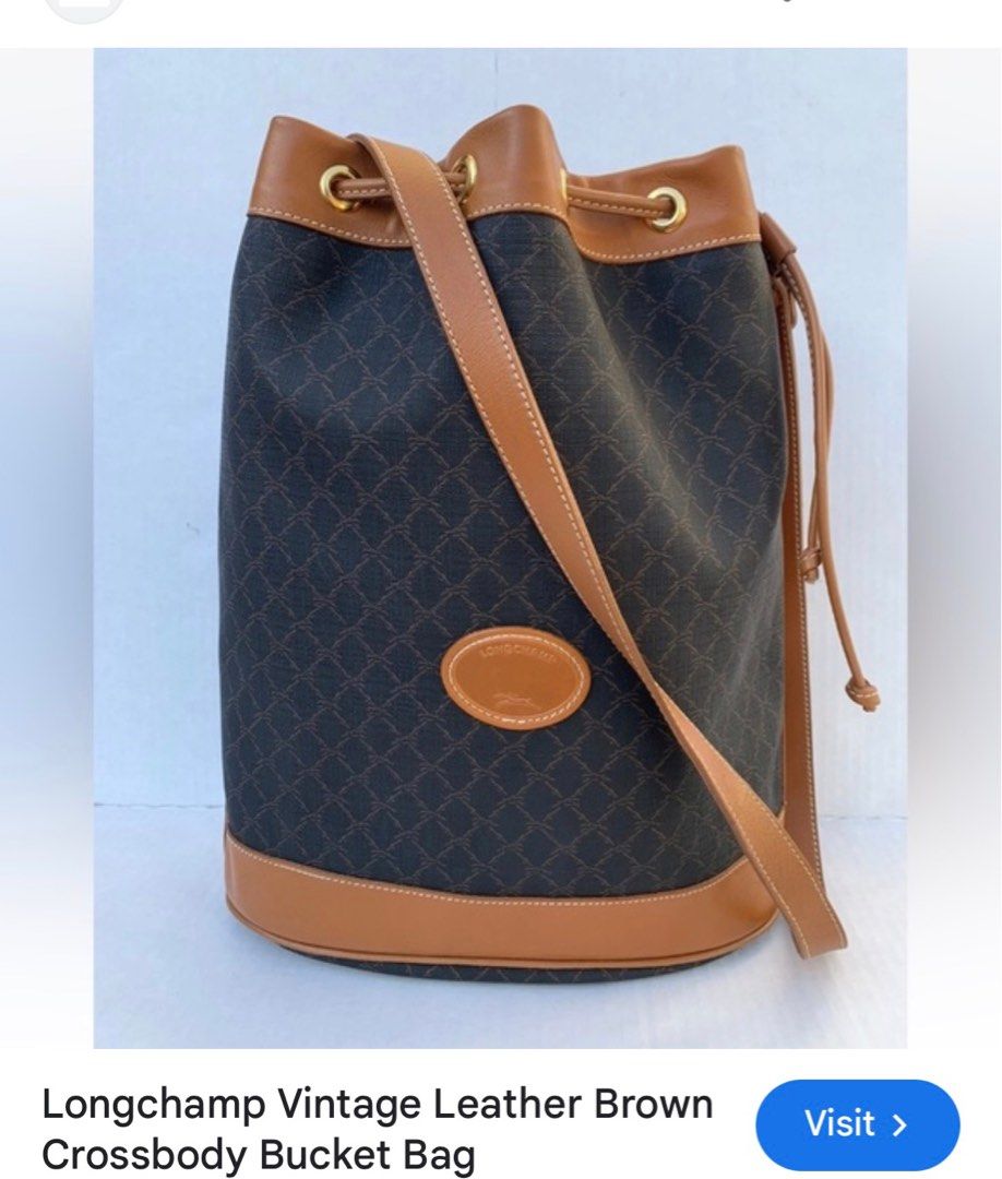 Longchamp Vintage Leather Bucket Bag (Category: Luxury Bags & Wallets) located in Rosales. Submitted by thriftingismygame (Listing ID 1405217703, Image 1). Description: - Vintage Longchamp bucket bag - Brown leather trim and strap - Drawstring closure - Brown patterned exterior - Features Longchamp logo patch - Beige interior with zipper pocket - Made in France Some few signs of usage.