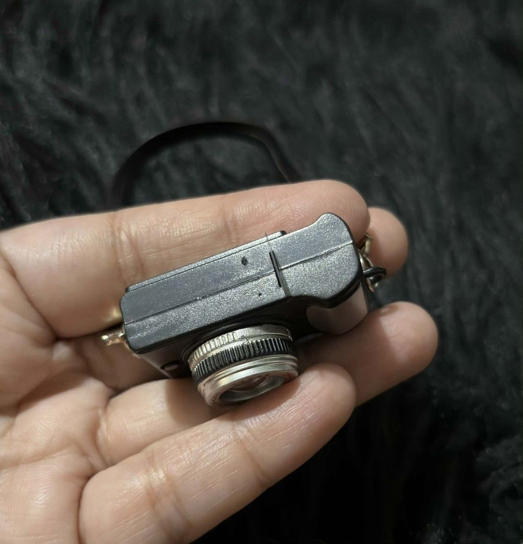 Miniature Camera with Strap (with light & sound) (Category: Cameras) located in Paranaque City. Submitted by dallecloset_ii (Listing ID 1405223871, Image 3). Description: Miniature black and silver camera with strap. Features a flash and "ZHONGYANG OPTICALS" lens. Perfect for collectors or display. working po yung flash & sound nya.