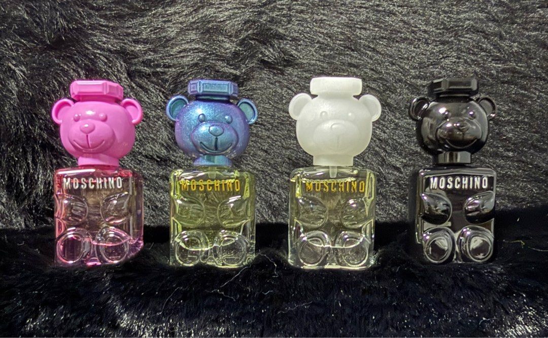 Moschino Toy 2 Eau de Parfum (Category: Fragrance & Deodorants) located in Bacoor. Submitted by cielo1985 (Listing ID 1405312215, Image 1). Description: - Set of four Moschino Toy 2 Eau de Parfum bottles. - Each bottle is shaped like a teddy bear. - Colors: Pink, Blue, White, and Black. - Features the Moschino logo on the front. - Displayed on a black, furry surface..