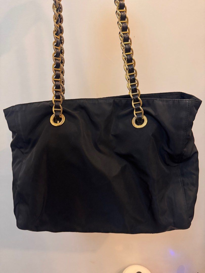Prada Black Nylon Tote Bag with Chain Straps (Category: Luxury Bags & Wallets) located in Manila. Submitted by kjbsb_041 (Listing ID 1405164094, Image 3). Description: - Authentic Prada tote bag - Black nylon exterior - Gold-tone chain straps with leather detailing - Prada logo on the front - Zipper closure - Tote style With minimal Flaws on the exterior. No other inclusions. Location: Taytay Rizal. MOP: BDO, BPI only. .