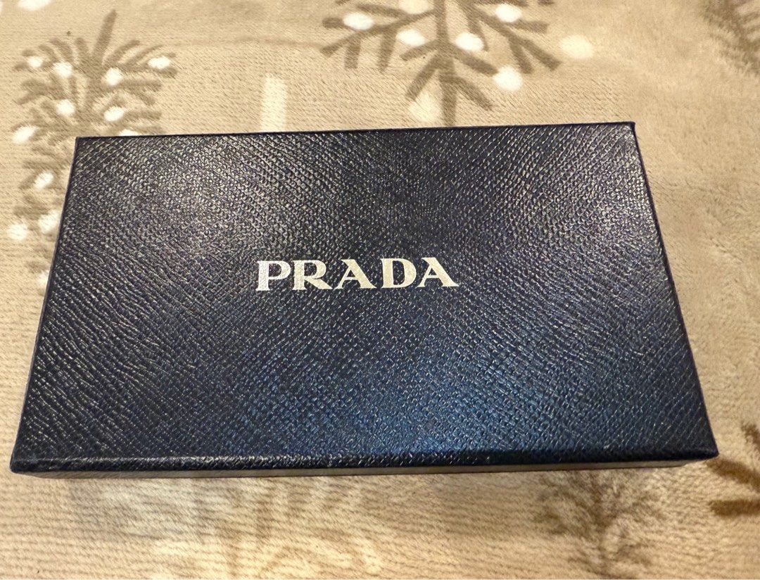 Prada Wallet Box (Category: Luxury Bags & Wallets) located in Lipa City. Submitted by Msjhen (Listing ID 1405240303, Image 1). Description: - Authentic Prada box set - Includes original box, tissue paper, and card - Navy blue box with Prada logo - Interior features Prada logo pattern - Card in black Prada envelope - Ideal for gifting or storing Prada wallets.