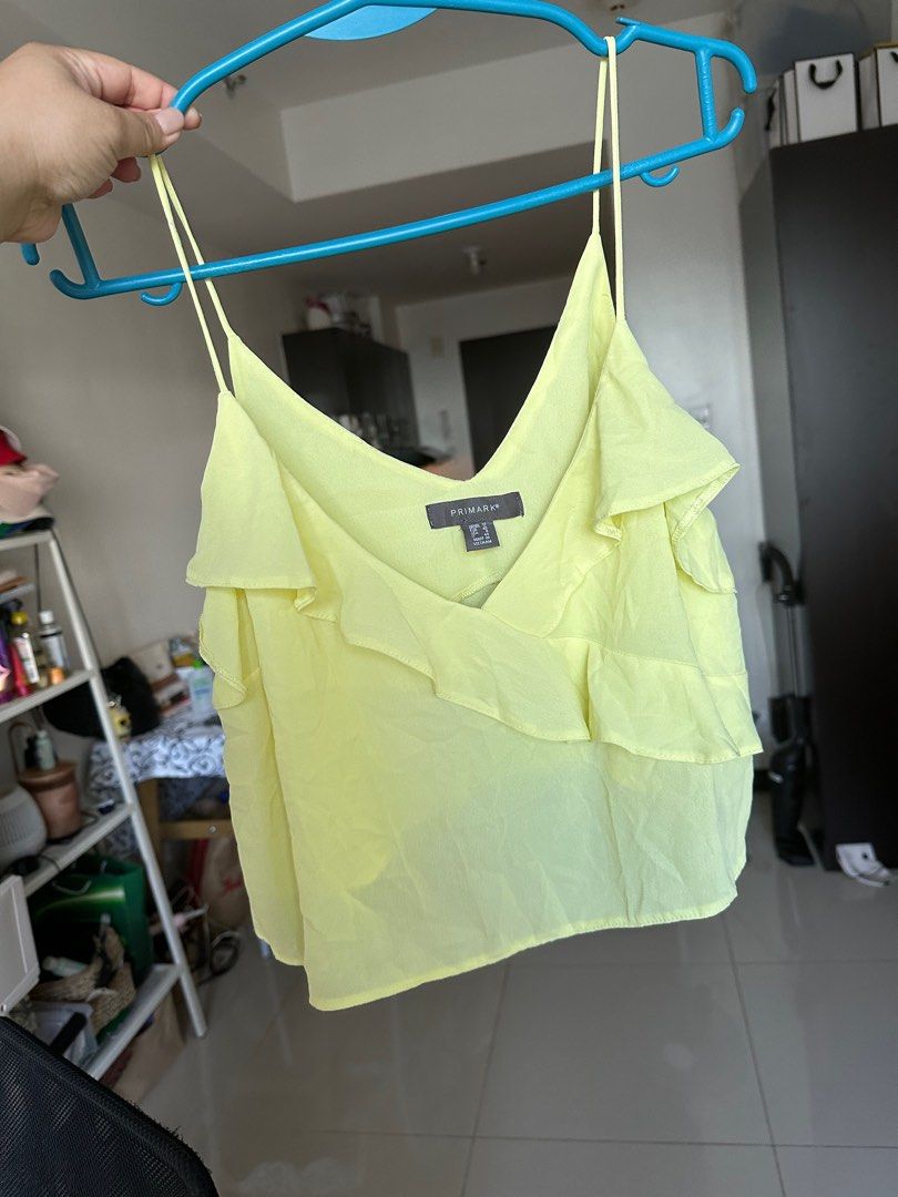 Primark Yellow Cami Top (Category: Sleeveless) located in Manila. Submitted by yourdeclutterdiva (Listing ID 1405250583, Image 1). Description: - Primark cami top - Vibrant yellow color - Layered design - V-neckline - Thin straps - Made of lightweight, flowy fabric - Versatile style.