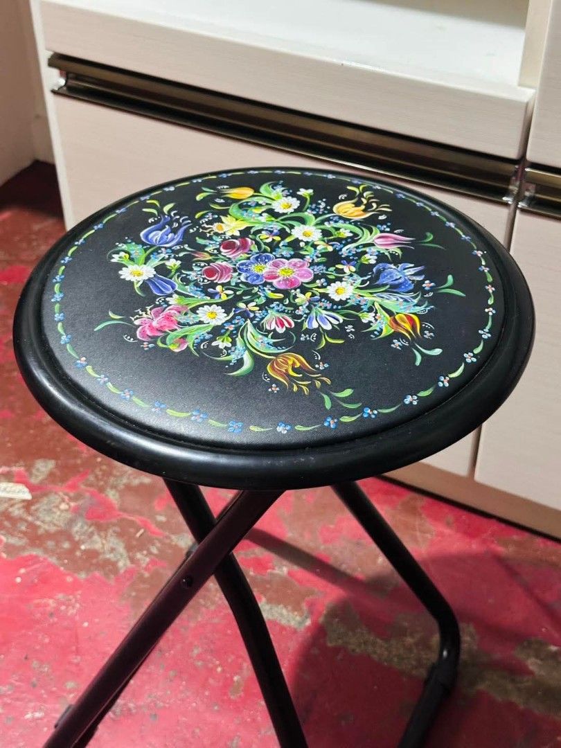 Vintage Floral Design Folding Stool (Category: Chairs) located in Imus. Submitted by umusthave23 (Listing ID 1405327468, Image 2). Description: Round Folding Stool Like new Dia. 12.5in x H18in Folding stool with a vibrant floral design - Round seat with colorful flowers on a black background - Sturdy black metal frame - Folds flat for convenient storage - Ideal for both indoor and outdoor settings.
