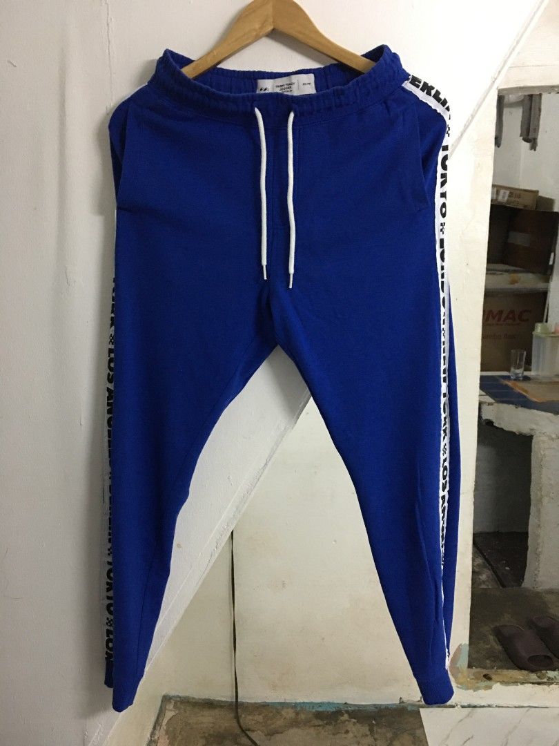 Cotton On Trippy Track Jogger Pants (Category: Joggers) located in Quezon City. Submitted by 2high2cry. (Listing ID 1405515436, Image 1). Description: - Cotton On Trippy Track jogger pants - Color: Blue with white accents - Size: XXS/PXP - Features: Drawstring waist, relaxed fit - Design: White band with city names (Berlin, Tokyo, London, New York, Los Angeles).