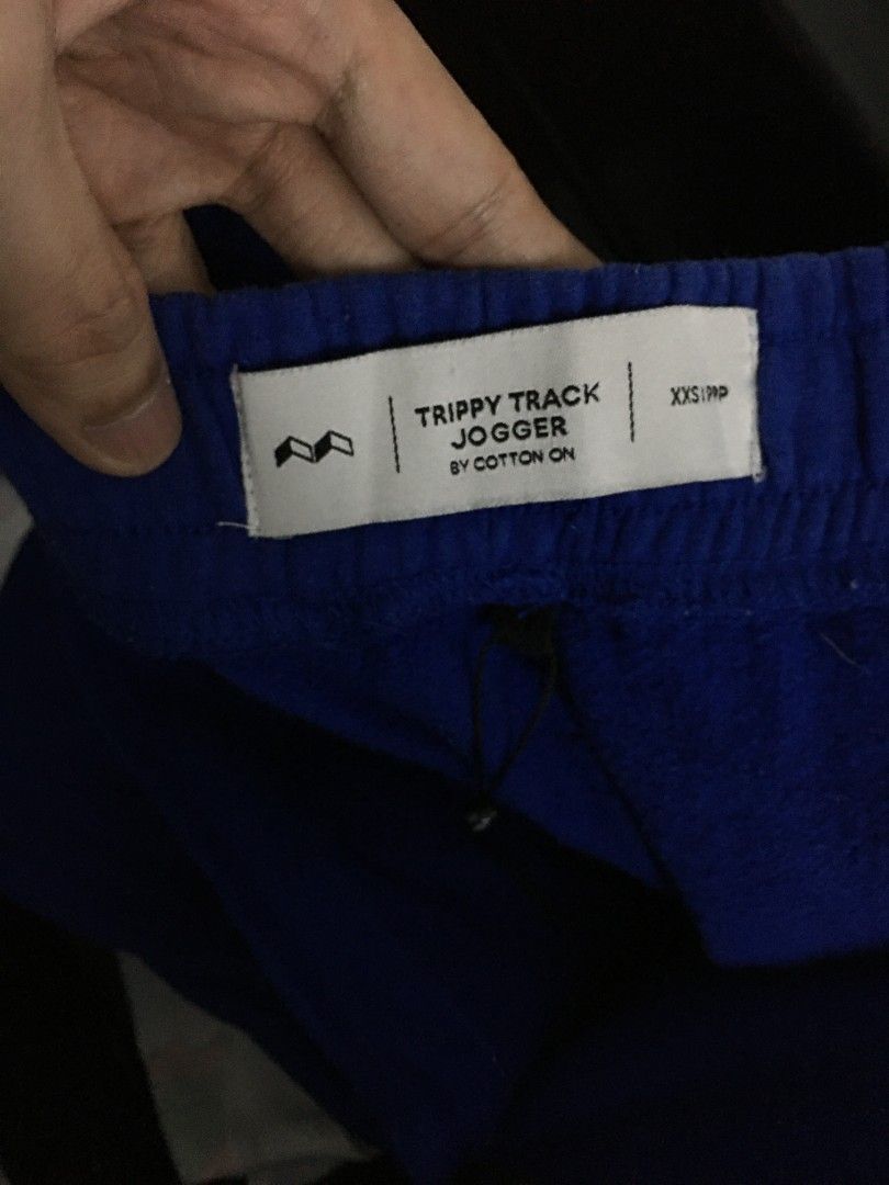 Cotton On Trippy Track Jogger Pants (Category: Joggers) located in Quezon City. Submitted by 2high2cry. (Listing ID 1405515436, Image 3). Description: - Cotton On Trippy Track jogger pants - Color: Blue with white accents - Size: XXS/PXP - Features: Drawstring waist, relaxed fit - Design: White band with city names (Berlin, Tokyo, London, New York, Los Angeles).