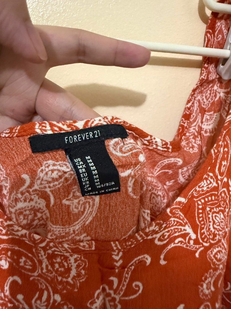 Forever 21 Paisley Tank Top (Category: Sleeveless) located in Manila. Submitted by iamroxv (Listing ID 1405498434, Image 2). Description: - Forever 21 tank top - Orange and white paisley pattern - Scoop neck - Lace trim - Size: Medium - Made in China.