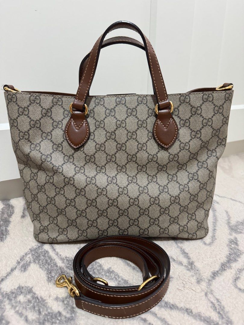 Gucci GG Supreme Small Tote Bag (Category: Luxury Bags & Wallets) located in Quezon City. Submitted by preloveditemsbyc (Listing ID 1405421911, Image 1). Description: This bag is crafted of Gucci GG monogram coated canvas. It features brown leather top handles, magnetic top closure and an optional shoulder strap with gold-tone hardware. The top opens to a suede interior with one zipper pocket and two patch pockets. Length: 11” Height: 8.75” Width