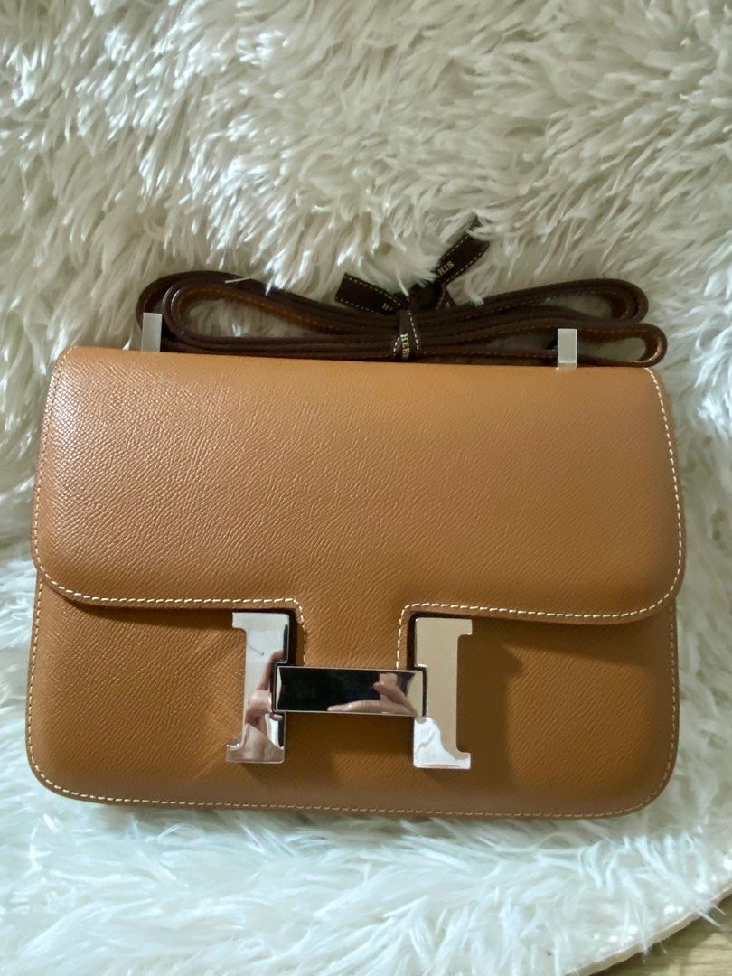 Hermes Constance 24 Bag (Category: Luxury Bags & Wallets) located in Las Pinas. Submitted by shaina1111 (Listing ID 1405393133, Image 1). Description: - Authentic Hermes Constance 24 - Elegant tan leather - Silver-tone 'H' clasp - Matching shoulder strap - Classic white stitching - Includes Hermes ribbon.