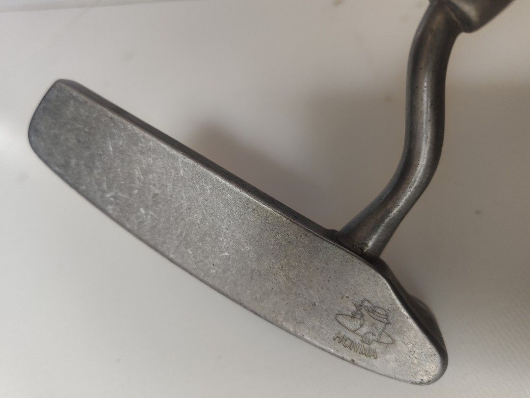 Honma Golf Putter (Category: Golf) located in Manila. Submitted by babz30261 (Listing ID 1405399457, Image 1). Description: - Honma golf putter - Made in Japan - Unique curved shaft design - Honma logo engraved on the putter head - Honma logo on the dark grip - Gold band detail on the shaft.