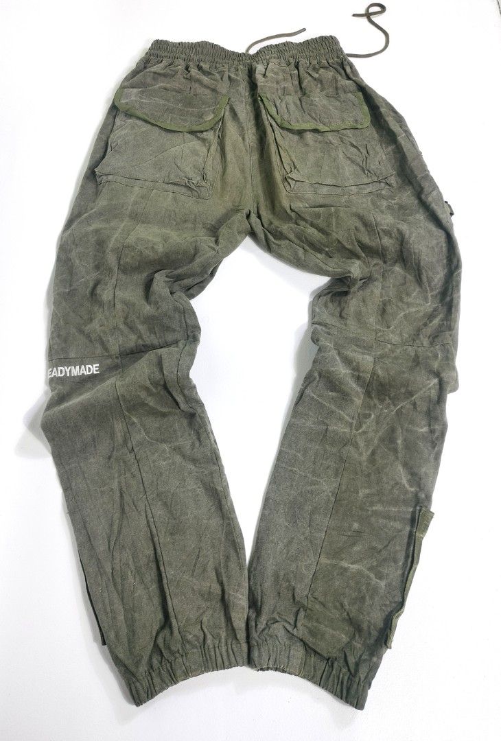 Readymade Track Pants Cacktus Jack (Category: Joggers) located in Manila. Submitted by callmetin (Listing ID 1405507713, Image 2). Description: Readymade track pants in size 3. Features multiple pockets, including cargo pockets with tiger stripe camouflage lining. Includes a drawstring waist and zippers. The pants have "READYMADE" printed on the side and a pink embroidered design. Made from vintage cotton Condition : Verygood Size : 3 Actual 👇 W